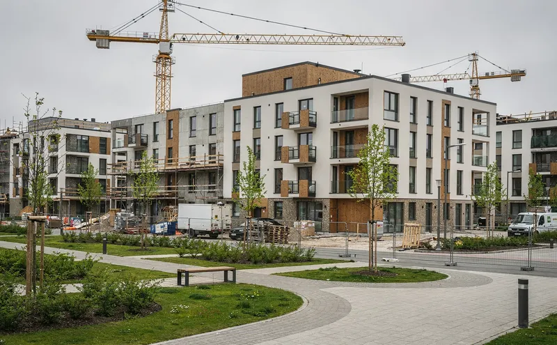 Byggarbetsplats med flerbostadshus under uppförande och grönytor