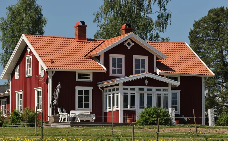 Vardagsrum med kaffekoppar och papper på bord, symboliserar ekonomisk planering