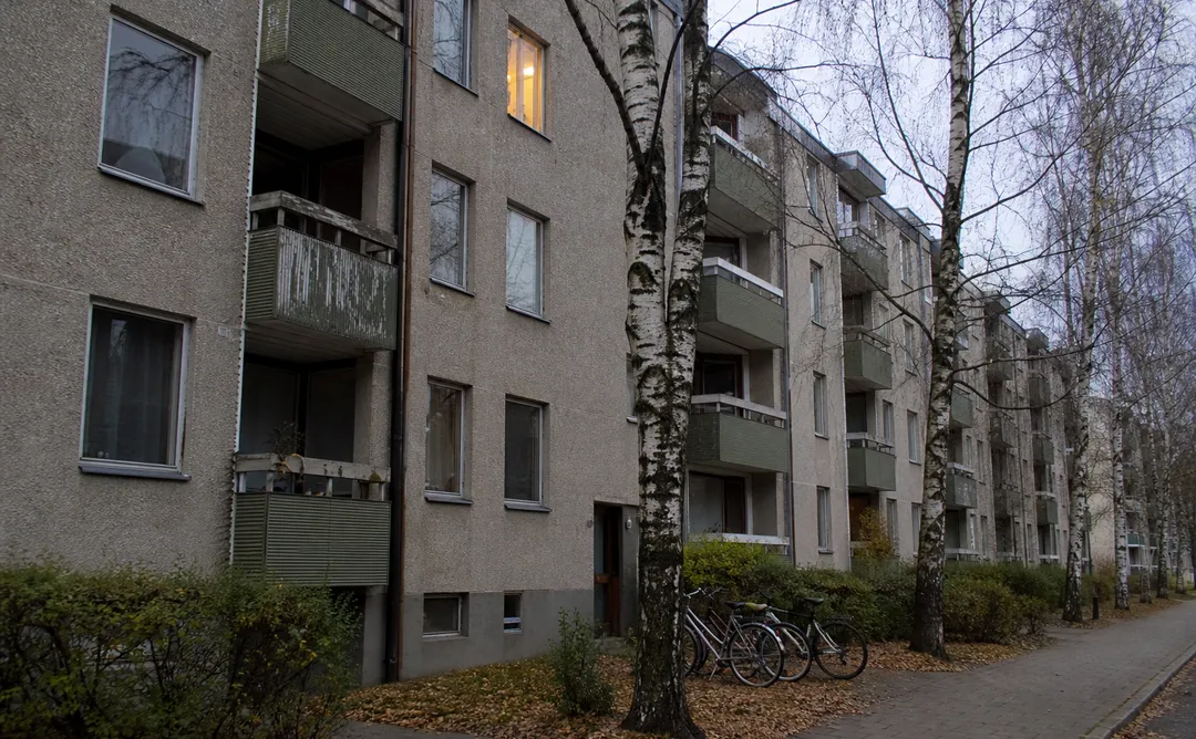 Kommunalt hyreshus i Sverige med balkonger och björkträd framför fasaden